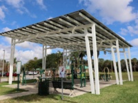 An FPL SolarNow solar canopy covers exercise equipment at Reverend Samuel Delevoe Memorial Park
