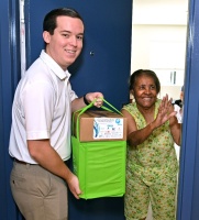 FPL's External Affairs Manager Christopher Ferreira (left) delivers hurricane preparedness meal kits to homebound resident Maria D. Mercedes (right) in Miami-Dade County.