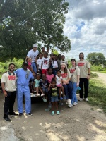 Dr. Roger Phanord, in blue scrubs, poses with dental students participating in the missionary trip and children from Las Matas de Farfan, Dominican Republic.