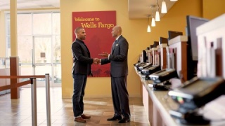 Male Wells Fargo employee shaking hands with another male in front of a teller (Photo: Wells Fargo)